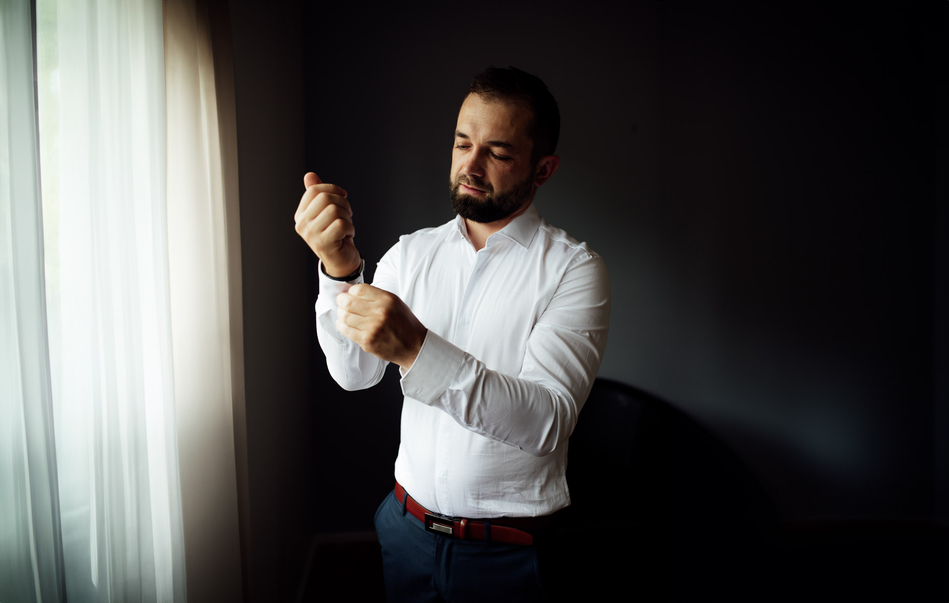 Groom putting on cufflinks